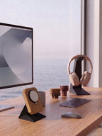 KI-generiertes Bild: Ein heller, aufgeräumter Arbeitsplatz an einem Holztisch mit Blick auf das Meer durch ein großes Fenster. Rechts steht ein Computerbildschirm mit einem Holz-MagSafe-Ladeständer davor und einer Kaffeetasse daneben. Auf dem Tisch liegen eine graue flache Tastatur und eine passende Maus. Links befindet sich ein schwarzer Kopfhörerständer mit beigen Over-Ear-Kopfhörern, davor stehen zwei kleine, handgefertigte Holzroboter-Figuren.